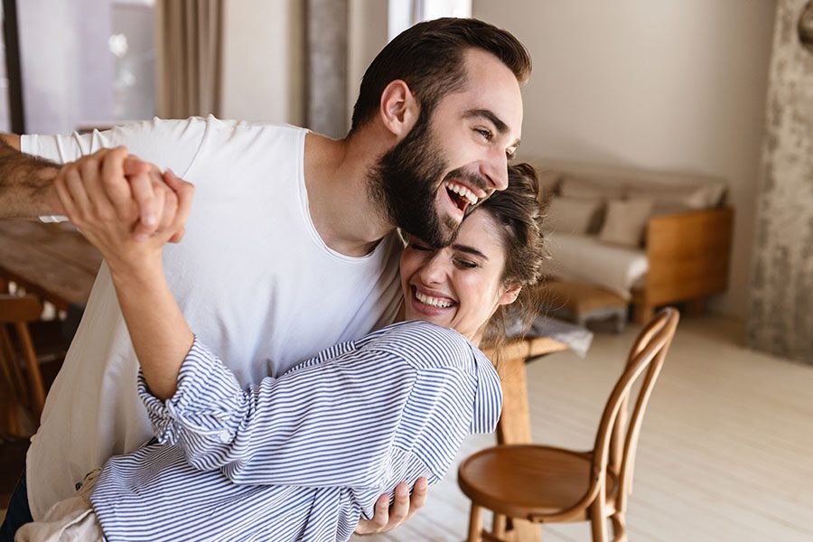 Personal Insurance - Smiling Young Couple Dancing in Their New Home